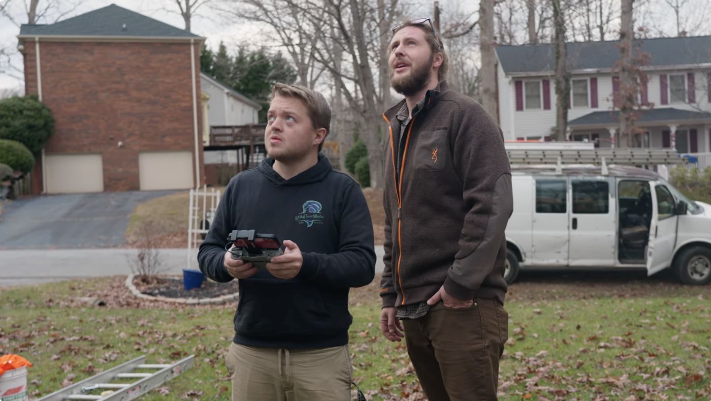 Peyton Crawford of Top Roofing watching a drone shot with Dylan